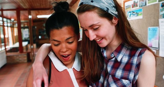 Two Female Friends Smiling and Looking at Something - Download Free Stock Images Pikwizard.com