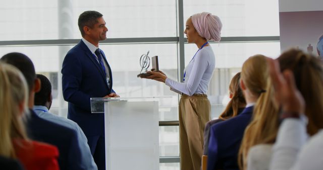 Side view of a Caucasian businessman receiving an award from a businesswoman while the public is applauding him in the business seminar 4k