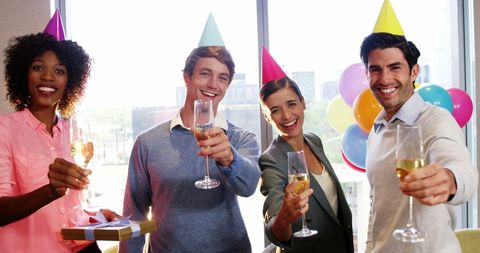 Cheerful Team Celebrating at Office Party with Champagne