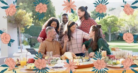 Friends sharing outdoor thanksgiving feast around sunlit patio table