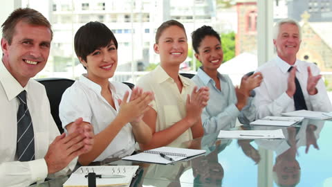 Diverse Business Team Applauding at Meeting Table