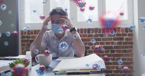 Stressed office worker wearing mask surrounded by corona viruses