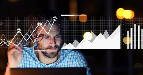 Businessman Analyzing Financial Data with Laptop at Night