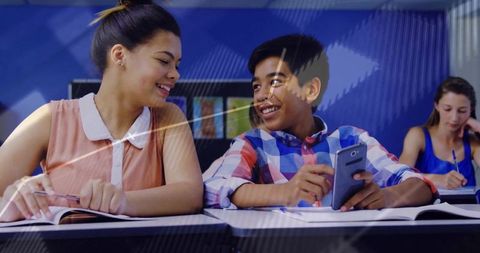 Smiling Students Engaged in Classroom Collaboration with Smartphones