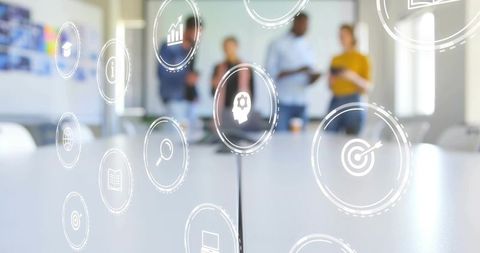 Business team collaborating with floating ar icons over conference table