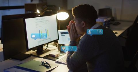Late-night analyst studying monthly report, receiving social alerts, updating charts