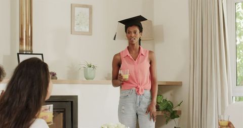 Woman in Graduation Cap Speaking at Home Reunion Celebration