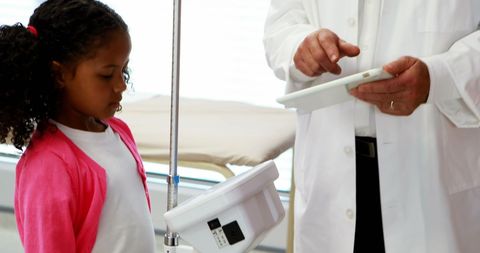 Healthcare Professional Consulting Young Girl Using Tablet