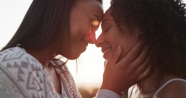 Romantic biracial lesbian couple smiling and embracing in garden at sundown, slow motion. Lifestyle, relationship, togetherness, love, relaxation and free time, unaltered.