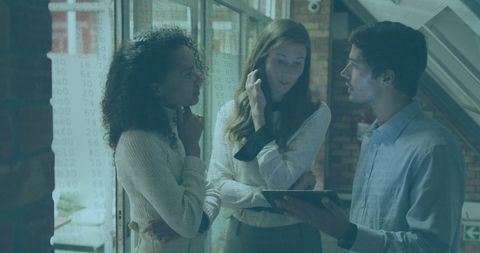 Diverse Team Collaborating on Tablet in Office Environment