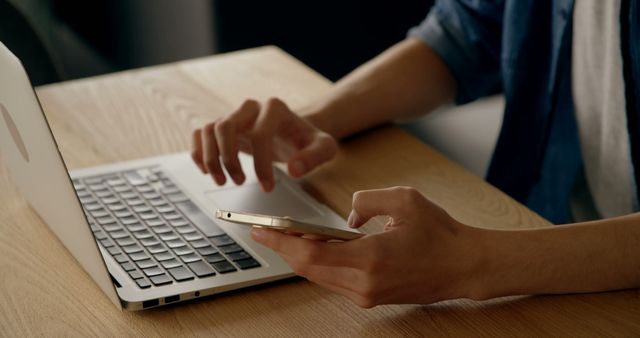 Person Texting on Smartphone While Working on Laptop at Wooden Desk - Download Free Stock Images Pikwizard.com