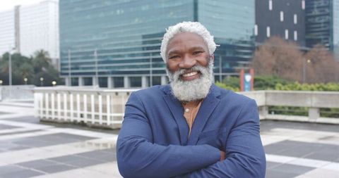 Senior African American Executive Smiling with Arms Crossed in Modern Urban Plaza