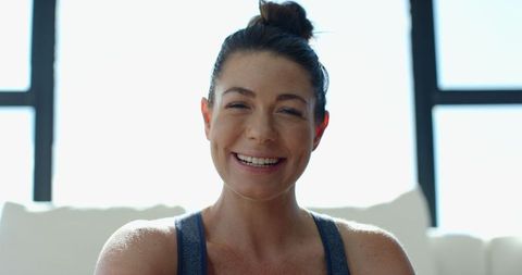 Smiling woman in relaxed home environment by bright windows
