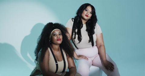 Diverse female duo posing with suspender style in studio