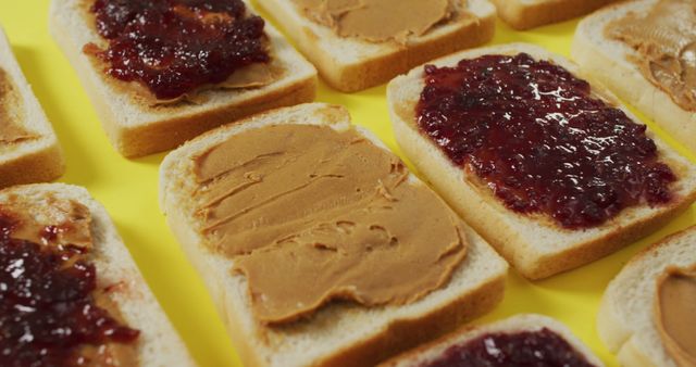 Slices of white bread on a yellow background, each topped with either peanut butter or jelly. Ideal for illustrating food concepts, recipes, or classic snack ideas. Perfect for blog posts, cooking websites, and educational materials on making sandwiches.