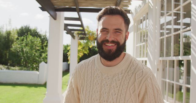 Bearded man enjoying sunny day outdoors, great for lifestyle blogs, fashion brands, personal care advertisements, relaxing atmospheres in gardening magazines.