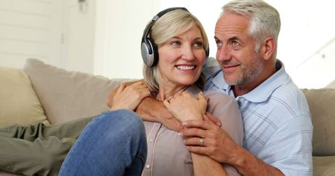 Happy Senior Couple Relaxing on Couch Listening to Music