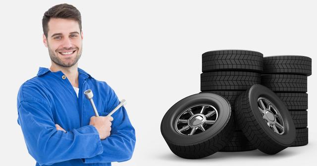 Mechanic in blue uniform holding lug wrench standing next to stacked tires on white background. Useful for automotive repair advertisements, blogs about car maintenance, tire shop promotions, and instructional content on tire changing. Represents professionalism, readiness to work, and automotive expertise.