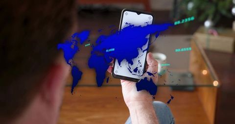 Senior man holding smartphone displaying holographic world map overlay and location data
