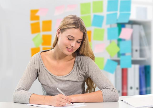 Woman writing notes with a background filled with colorful sticky notes. Ideal for concepts related to productivity, planning, brainstorming sessions, and study habits. Useful for educational materials, office-related content, and organizational tools promotion.