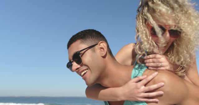 Young couple enjoying playful moment on sunny beach - Download Free Stock Images Pikwizard.com