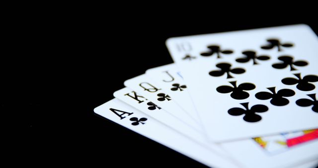 Classic representation of a royal flush poker hand, with cards in the clubs suit against a contrasting black background. Perfect for illustrating concepts related to card games, gambling strategies, and casino themes. Useful for websites, blog posts, marketing materials, or educational resources that cover gaming, mathematics, or probability.