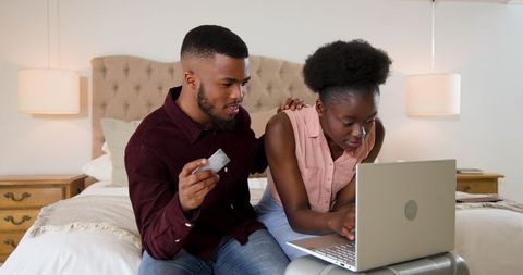 Young couple shopping online with laptop and credit card at home