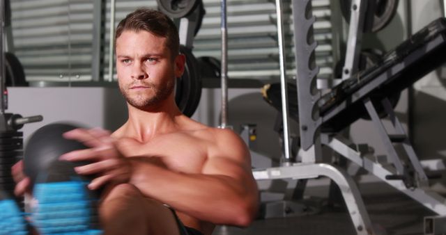 Focused Young Man Exercising with Medicine Ball in Gym - Download Free Stock Images Pikwizard.com