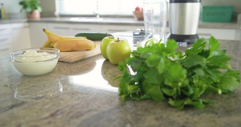 Fresh parsley with apples bananas yogurt on granite counter for green smoothies and meal prep