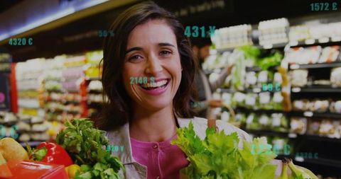 Smiling woman holding fresh produce in grocery aisle with digital price overlays