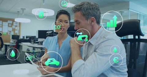 Business team collaborating on sustainable data dashboard with floating green tech icons