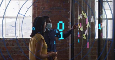 Collaborating with ar overlays while pointing at sticky notes on glass wall in loft