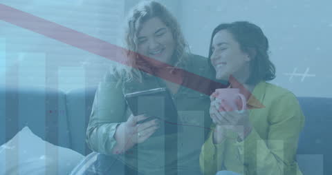 Lesbian Couple Enjoying Video Amid Falling Bar Graph Animation