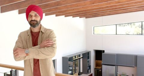 Confident man in modern home wearing red turban and casual outfit