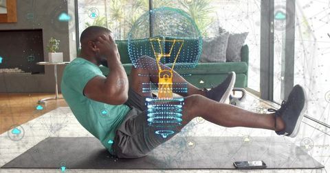 Man performing seated crunch with augmented fitness hologram in living room