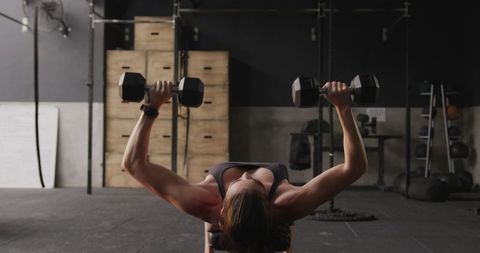 Fit Woman Strength Training with Dumbbells at Gym