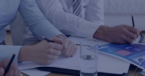 Business Professionals Reviewing Charts in Office Meeting