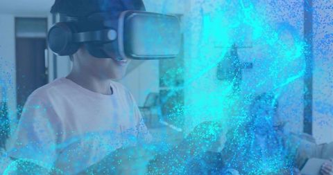 Child Experiencing VR Adventure at Home While Dad Observes, Reaching into Cyan Particles