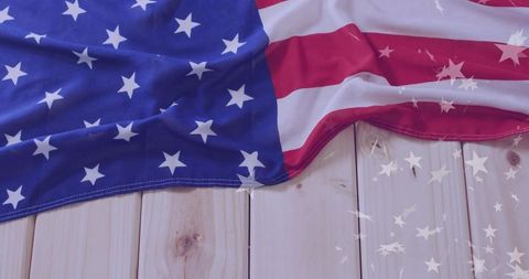 Draped American Flag on Light Wood with Star Reflections