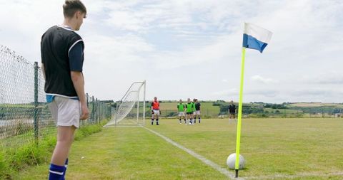 Young soccer player preparing for corner kick with teammates