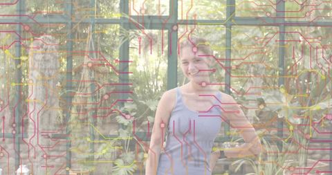Smiling woman wearing ribbed tank and smartwatch standing in greenhouse with circuit overlay