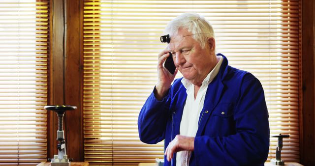 Elderly Man Speaking on Phone in Workshop - Download Free Stock Images Pikwizard.com