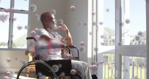 Senior man in wheelchair surrounded by virus illustrations reflection pandemic
