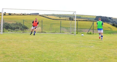 Soccer players training on rural field with rolling hills