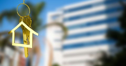 Golden House Key in Urban Cityscape Background