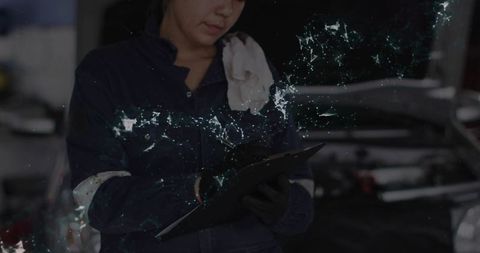 Female automotive technician analyzing vehicle engine at workplace