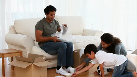 Family Enjoying Moving Home Unpacking Boxes Together