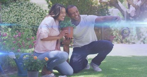 Couple Posing with Potted Plant in Vibrant Backyard Garden