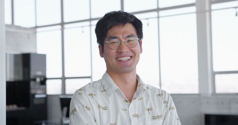 Confident asian male executive smiling in modern office environment