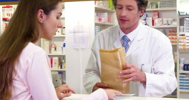 Pharmacist giving medicine package to customer at counter in pharmacy 4k
